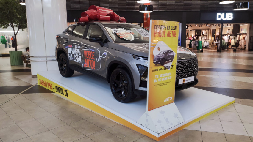 Рекламная экспозиция Omoda C5 с бантом в ТЦ