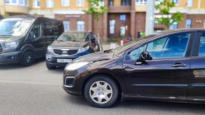 Автомобиль с повреждениями кузова и зеркала на городской улице