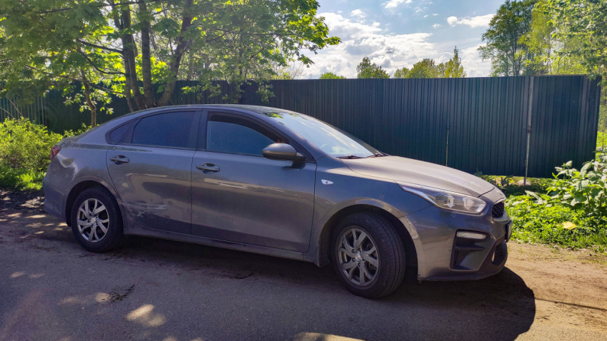 Серый автомобиль Kia с повреждением на двери