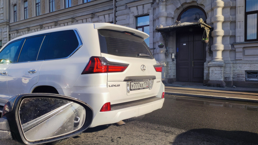 Белый внедорожник Lexus LX570 на городской улице
