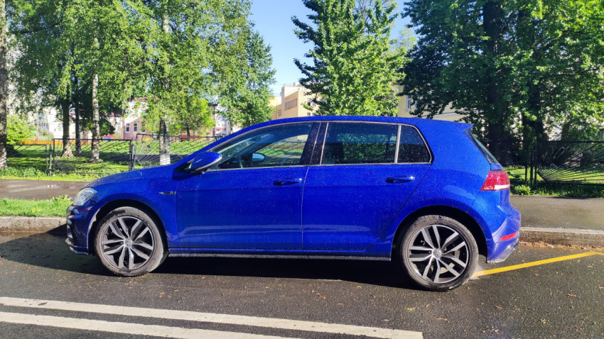 Синий автомобиль Volkswagen Golf на городской улице