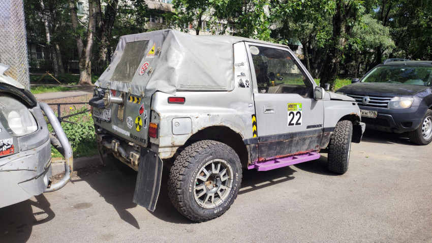 Задняя часть внедорожного автомобиля Suzuki с наклейками и лебёдкой