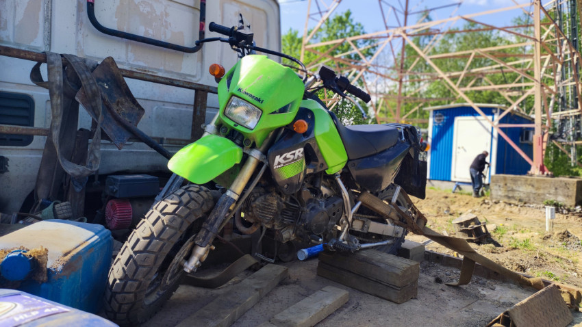 Мотоцикл Kawasaki KSR на грузовой платформе у строительной площадки