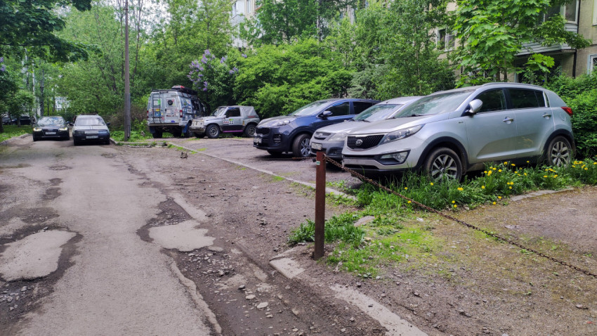 Парковка вдоль улицы с ямами на дорожном покрытии