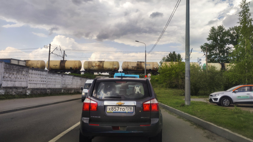 Железнодорожный поезд с цистернами на мосту над дорогой