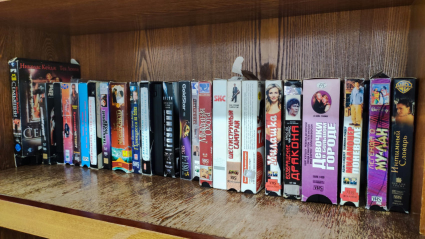 Ряд VHS-кассет с художественными фильмами и мультфильмами на полке