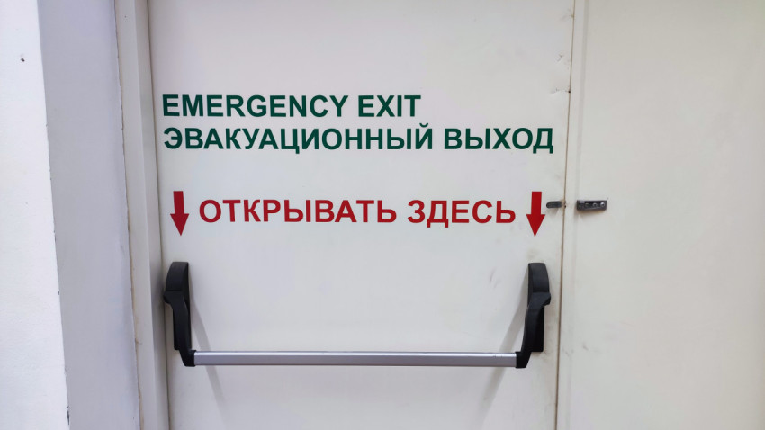 Надпись на двери эвакуационного выхода с указанием места открытия