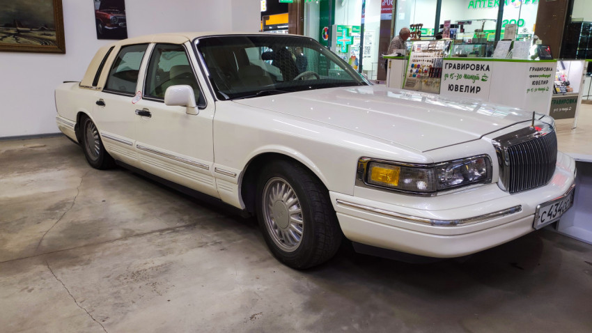 Белый седан Lincoln Town Car в музейной экспозиции