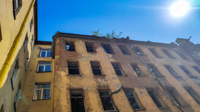 Полуразрушенный фасад здания во дворе
