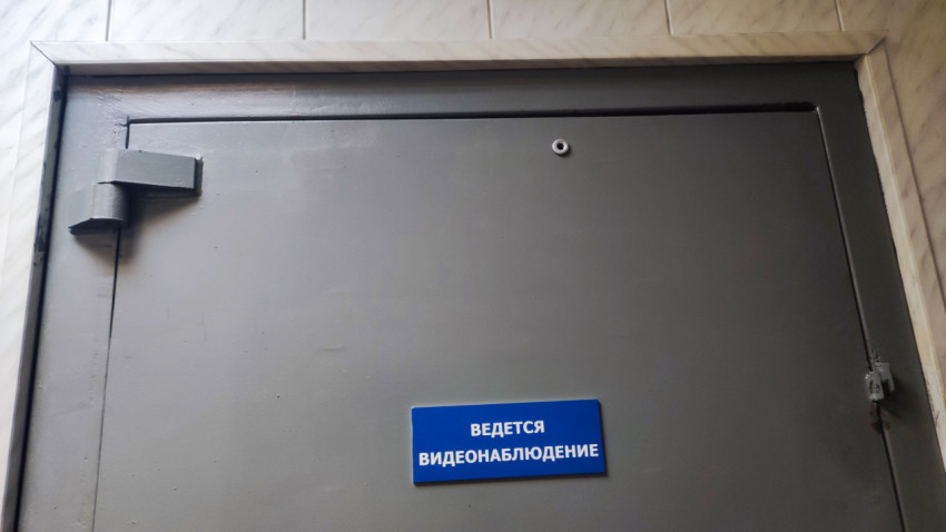 Металлическая дверь с табличкой о видеонаблюдении