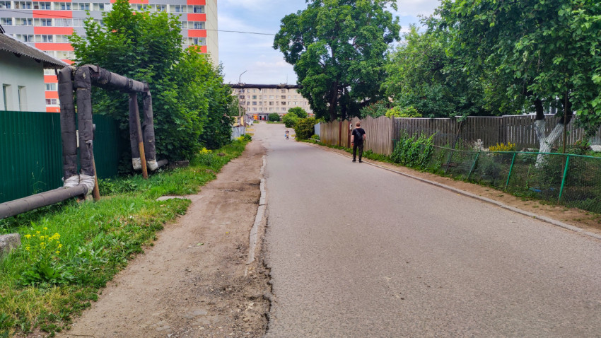 Асфальтовая улица с наружным трубопроводом и жилыми домами