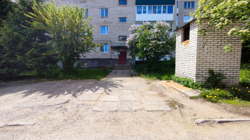 Подъезд многоквартирного дома с зелеными насаждениями