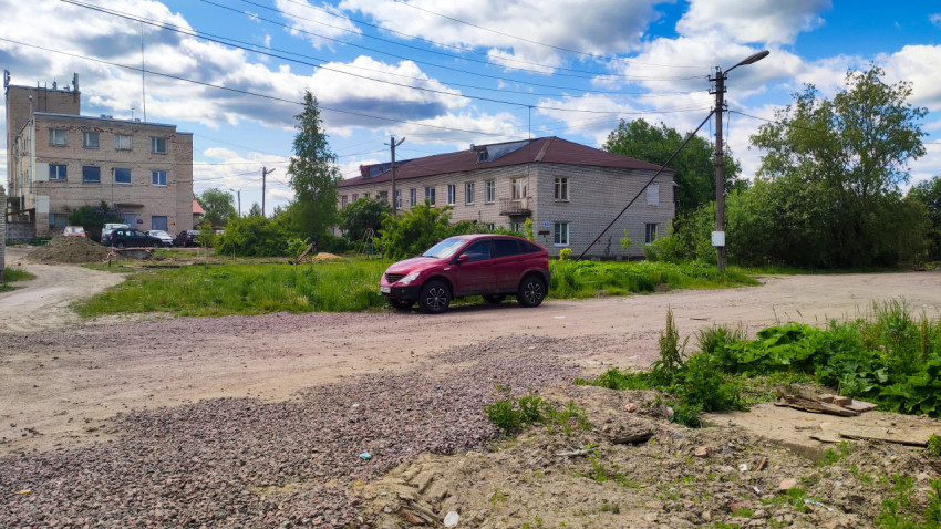 Двор жилого квартала с припаркованным автомобилем и жилыми домами