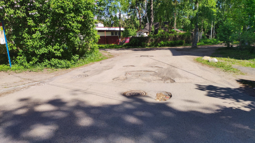Разбитая дорога с люком и ямами