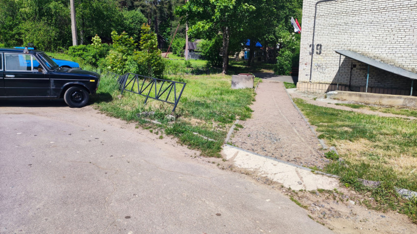 Придомовая территория с жилым домом и припаркованным автомобилем