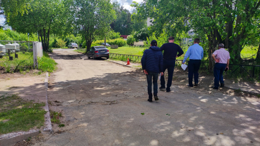 Группа людей на дворовой дороге у жилых домов