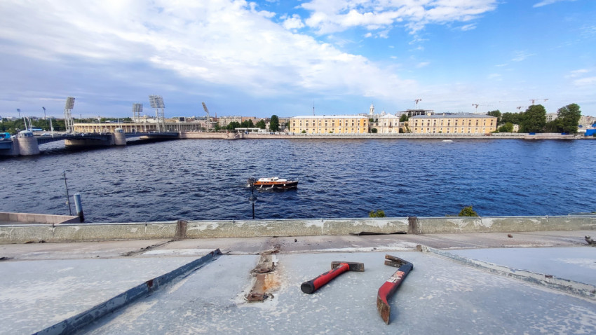 Панорама Невы с лодкой и строительными инструментами на переднем плане