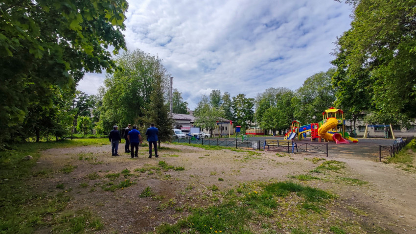 Городской двор с детской площадкой и проходящими людьми