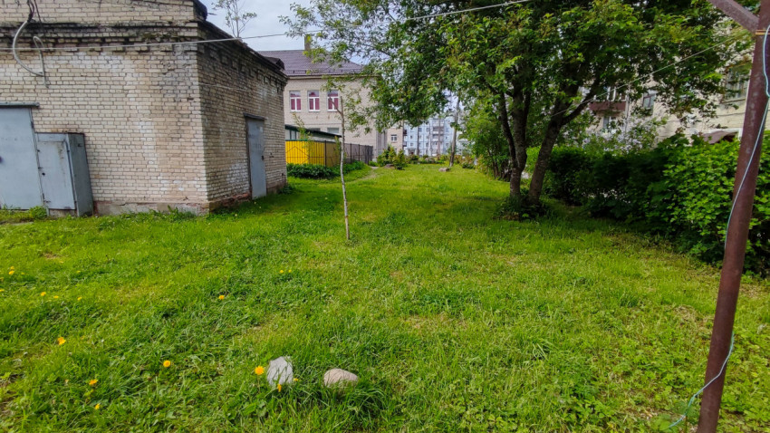 Кирпичная хозпостройка и зелёная полоса двора