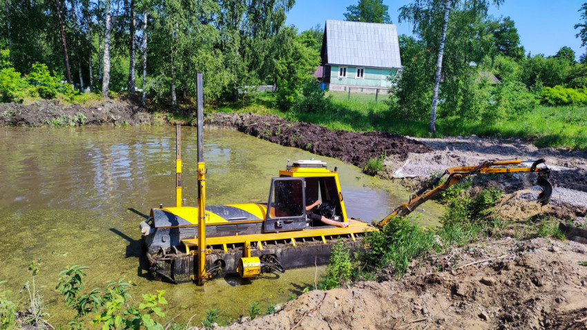 Экскаватор-амфибия работает в пруду