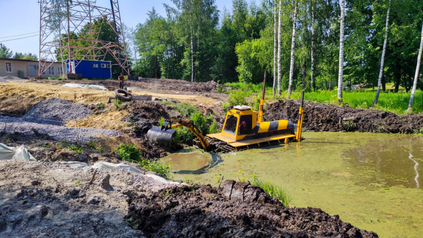 Экскаватор-амфибия очищает дно водоёма