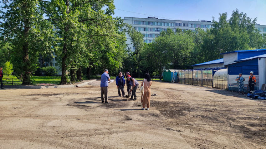 Рабочие осматривают участок дорожных работ во дворе