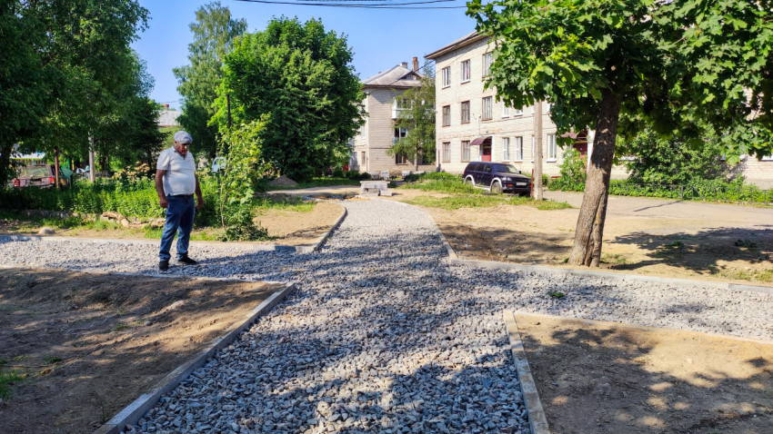 Рабочий проверяет щебёночную дорожку во дворе