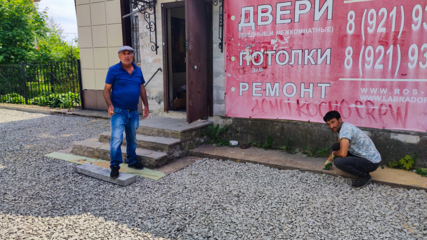 Рабочие у входа в здание во время благоустройства двора