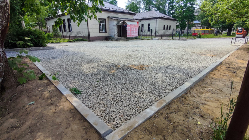 Вымощенная гравием площадка возле здания с бордюрами