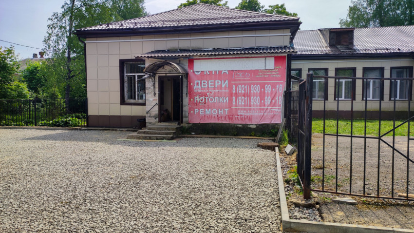 Фасад здания с баннером о ремонте и торговых услугах