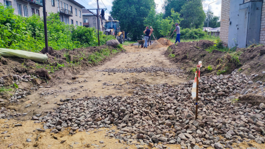 Рабочие готовят дорожное основание из щебня и песка