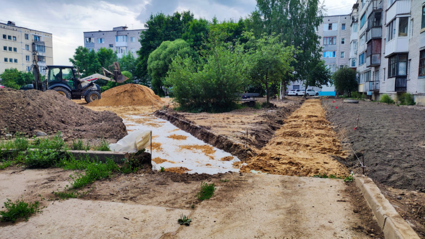 Экскаватор и земляные работы во дворе многоквартирного дома