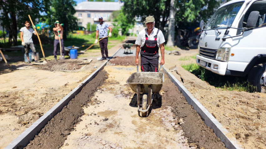 Рабочий с тачкой на строительной площадке