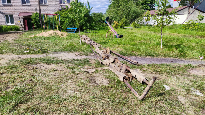 Старые трубы и детская площадка во дворе жилого дома