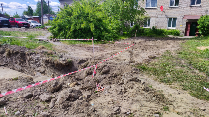 Земляные работы во дворе жилого дома с ограждением