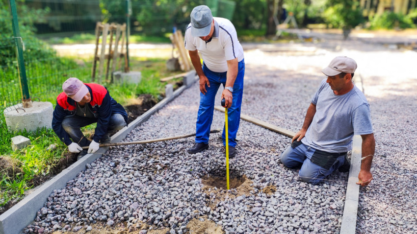 Рабочие проверяют глубину отверстия на строительной площадке