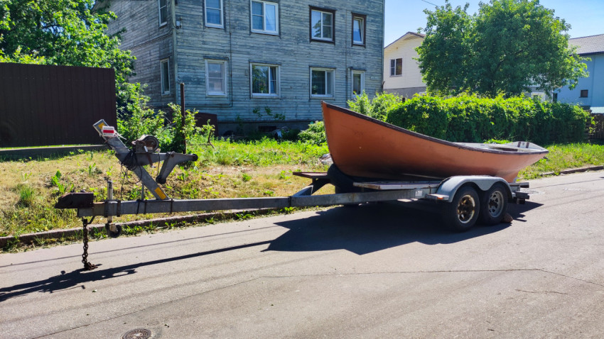 Лодка на прицепе сбоку у жилого здания