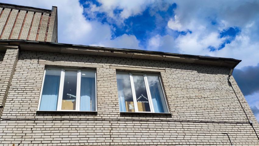 Кирпичный фасад здания с окнами и белыми рамами