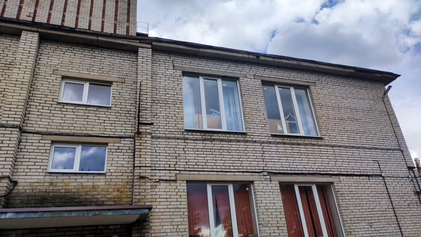 Кирпичный фасад здания с окнами и следами эксплуатации