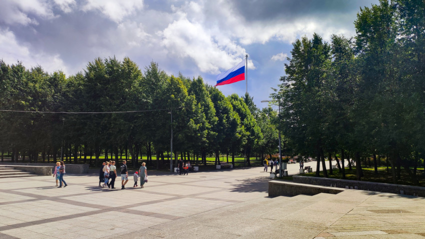 Российский флаг над парковой зоной с пешеходами