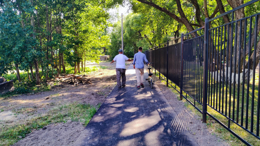 Люди идут по новой асфальтированной пешеходной дорожке