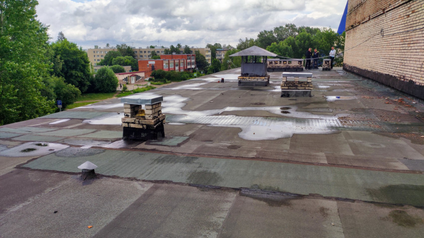 Крыша промышленного здания с лужами после дождя