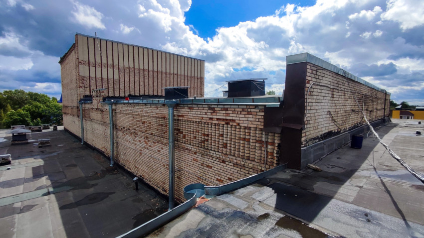 Кирпичная стена крыши с водосточной системой