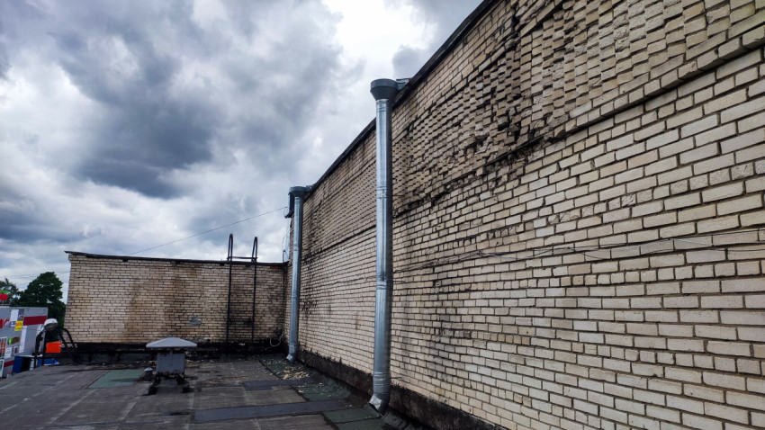 Фрагмент кирпичной стены здания с вентиляционными трубами