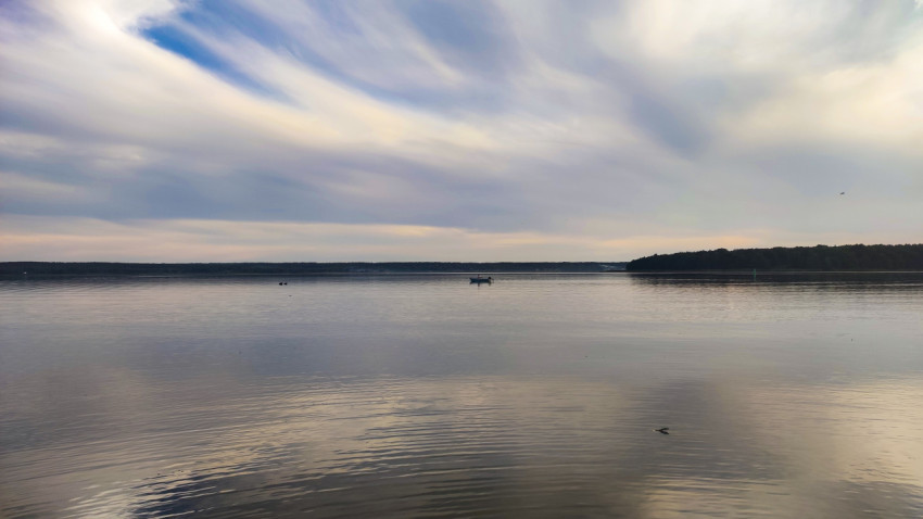 Лодка на озере под облачным небом