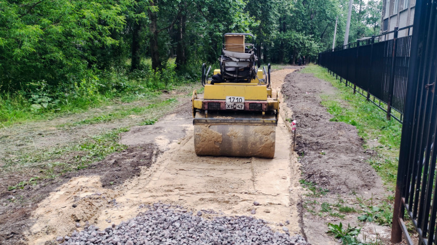 Дорожный каток уплотняет основание тротуара