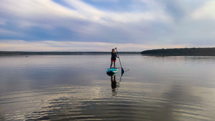 Человек на сапборде на озере
