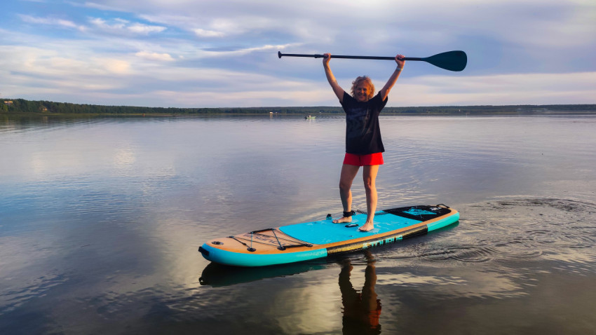 Женщина на сапборде с поднятым веслом