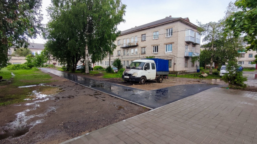 Асфальтированная дорожка во дворе жилого дома после дождя