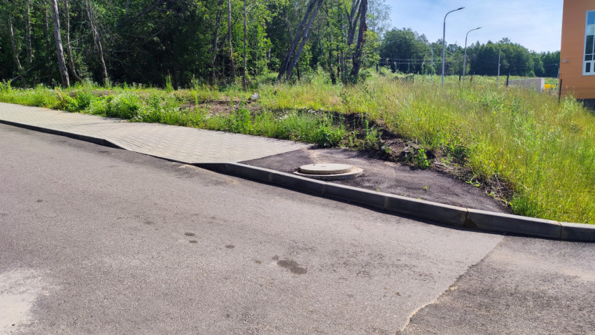 Новая асфальтовая дорога и пешеходная зона с тротуарной плиткой